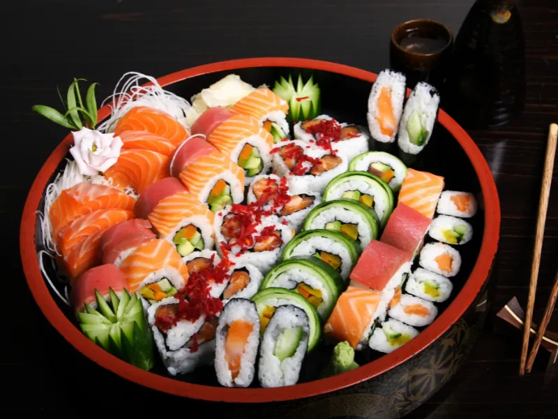 Large round platter filled with rich variety of mixed sushi and sashimi
