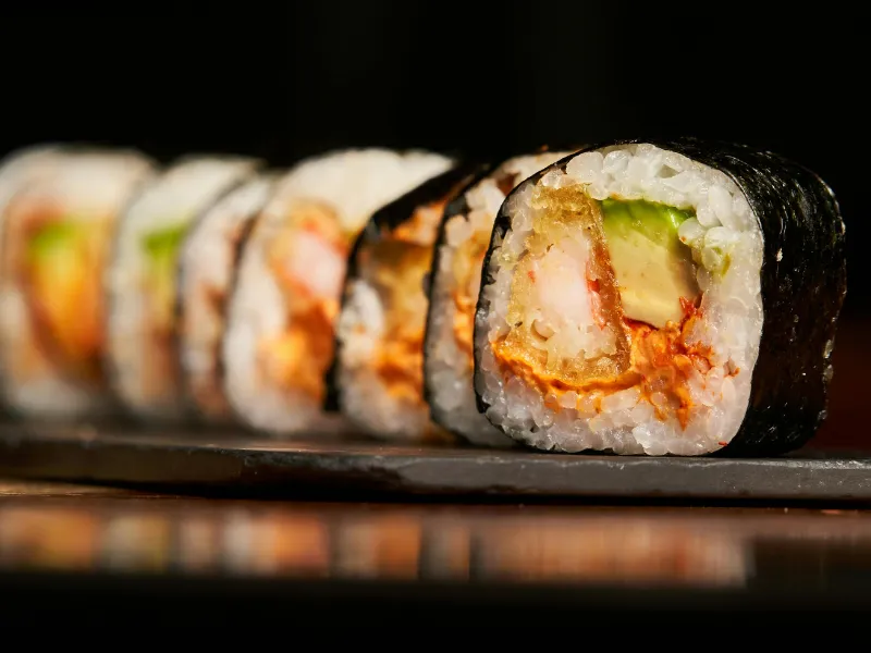 Nori‑wrapped sushi roll with fried shrimp, avocado and spicy sauce
