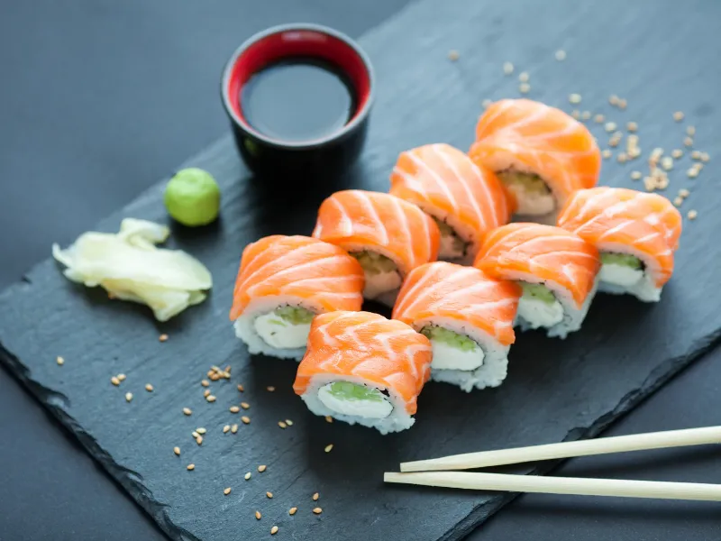 Salmon‑outside sushi roll with cream cheese, wasabi and sesame seeds